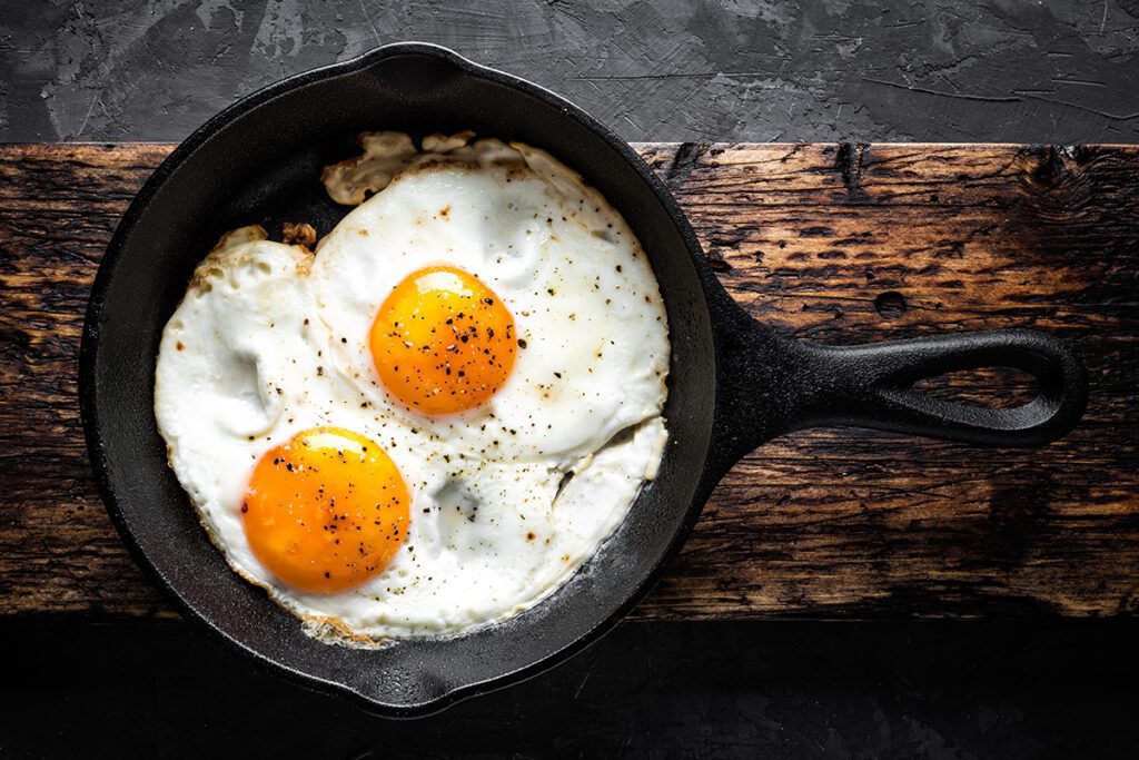 Fried eggs in a black cast iron pan.